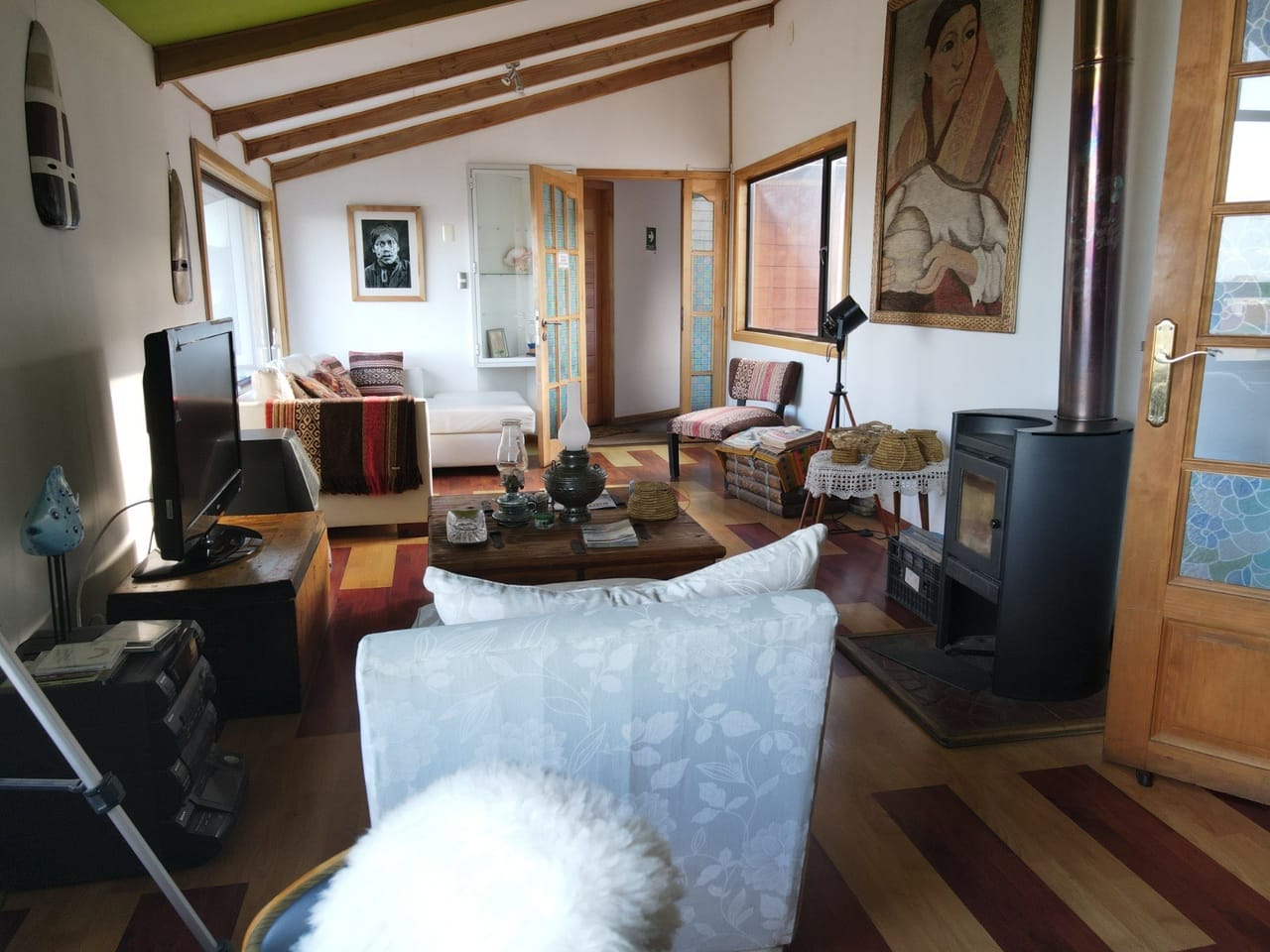 Sala de estar del hostal con estufa, vigas de madera y sillones